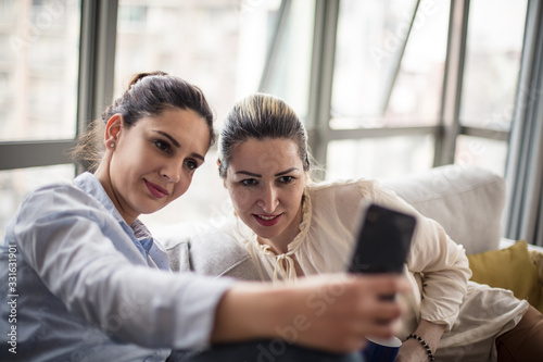 Celebrate the sisterhood with a self portrait. Two women taking self portrait.