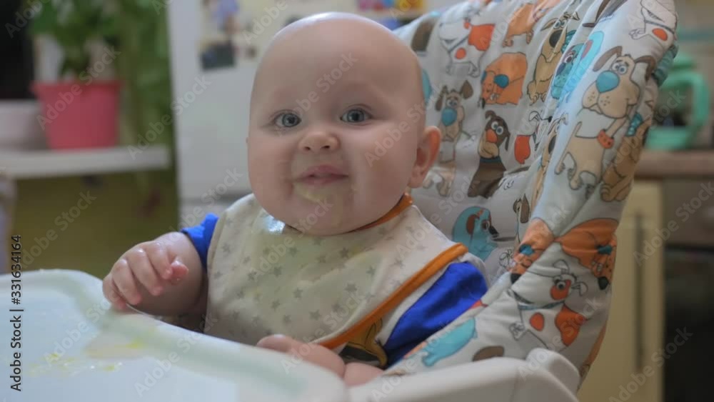 Mother feeding little baby with porridge at home kitchen. Mother feeding little baby with porridge at home kitchen.