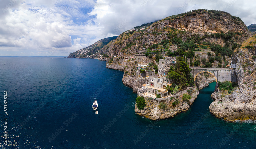 Aerial view of the rocky seashore of southern Italy. Boat. Incredible beauty panorama of mountains and sea. Travel and tourism. Sunny summer day. Fiordo di furore beach. Praiano, Amalfi coast.