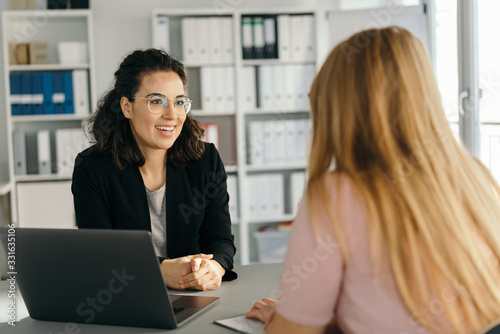 Smart businesswoman sitting listening to colleague