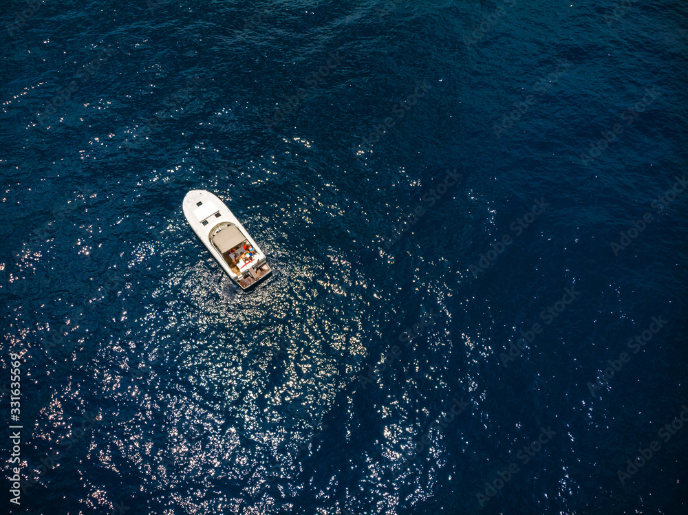 Small motor boat in blue sea. A little watercraft. Sunny summer day. Top down view, recreation and fishing. Movement on water. Tourism and travel. Copy space Small motor boat in blue sea. A little watercraft. Sunny summer day. Top down view, recreation and fishing. Movement on water. Tourism and travel. Copy space