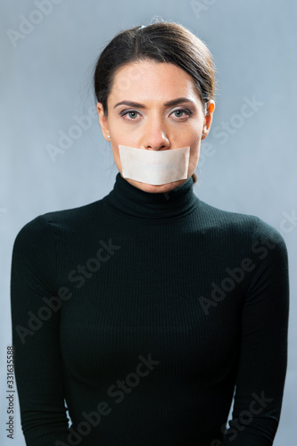 woman in black with mouth shut, portrait. ability to keep secrets. forced silence. censorship concept photo