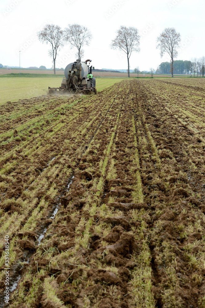 Epandage de lisier sur un champ par enfouissement dans le sol avec une tonne à lisier équipée d'un enfouisseur afin de limiter les odeurs. Sillons de lisier