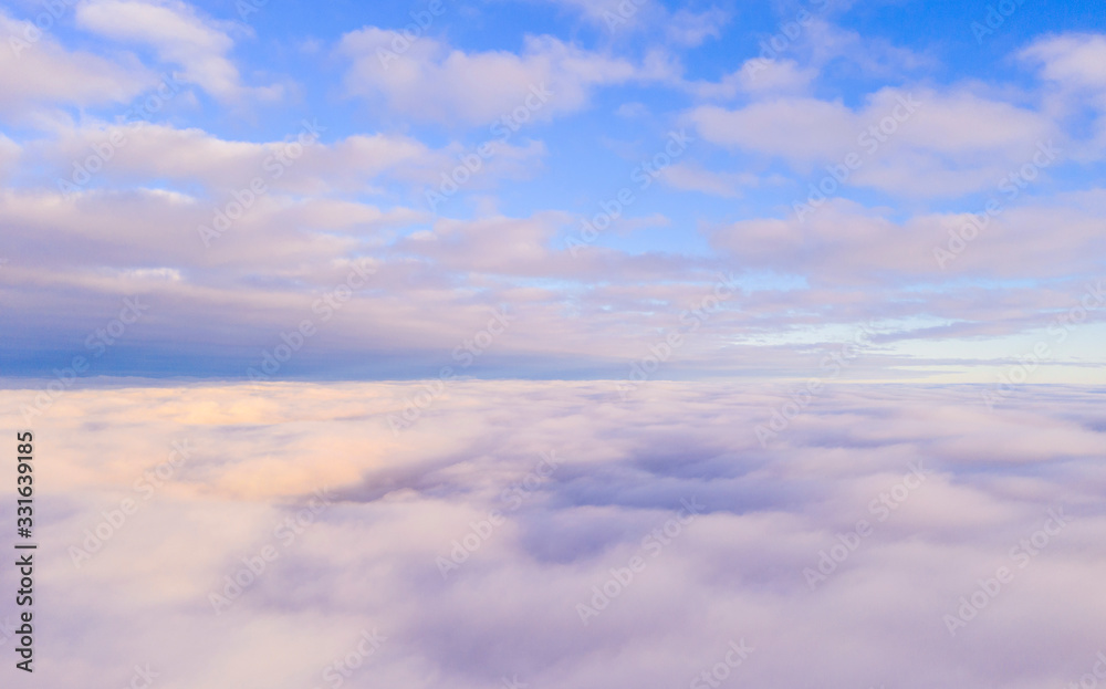 Aerial view White clouds in blue sky. View from drone. Aerial top view cloudscape. Texture of clouds. View from above. Sunrise or sunset over clouds. Panorama clouds