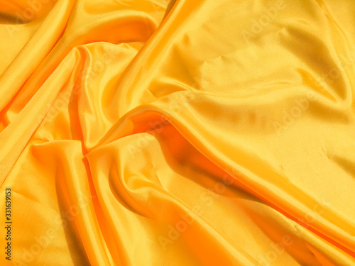 Bright yellow silk with waves moving for background. Abstract design with copy space