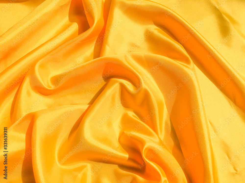 Bright yellow silk with waves moving for background. Abstract design with copy space Bright yellow silk with waves moving for background. Abstract design with copy space