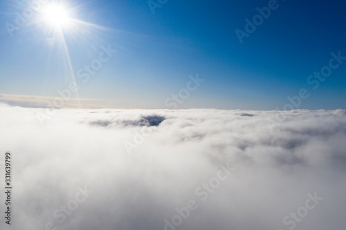 Fototapeta Naklejka Na Ścianę i Meble -  Aerial view White clouds in blue sky. View from drone. Aerial top view cloudscape. Texture of clouds. View from above. Sunrise or sunset over clouds. Panorama clouds