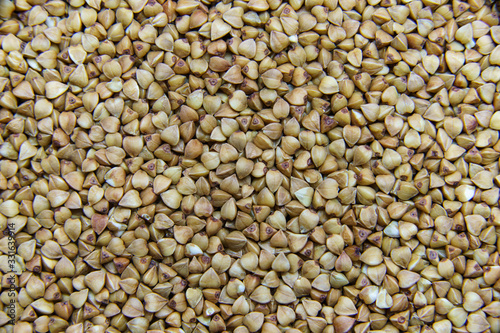 Brown dry uncooked buckwheat seeds macro. Healthy Russian food. Natural buckwheat grain background. 