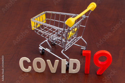 Shopping in coronavirus covid-19 time concept. Shopping cart with word covid19 close up.