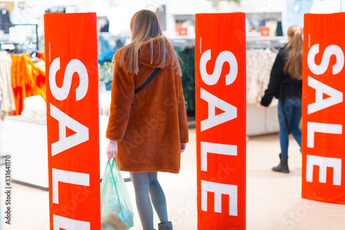 Young woman goes through a security anti-theft framework in a store