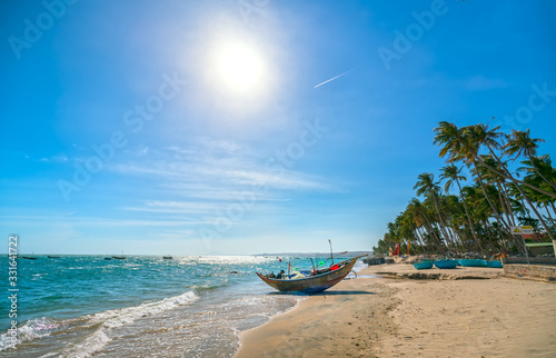 Fishing boat resting on a beach on a sunny afternoon waiting for the night to go out to sea fishing in the beautiful waters of Central Vietnam