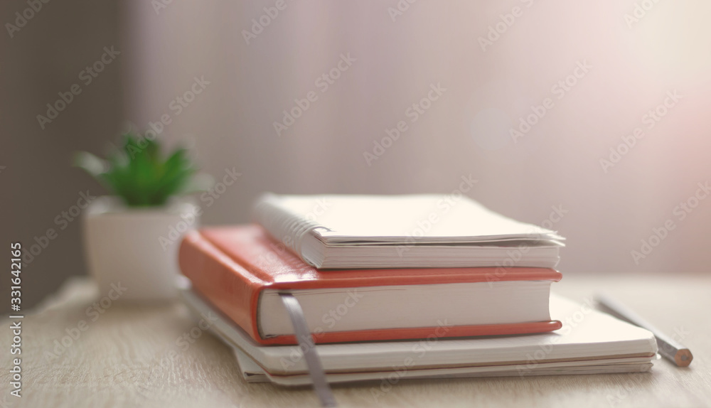 Workplace. Books, notebooks on the table opposite the window. Telework. Work at home. Workplace. Books, notebooks on the table opposite the window. Telework. Work at home.
