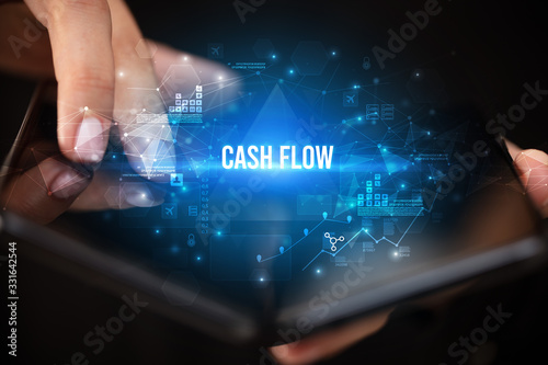 Businessman holding a foldable smartphone with CASH FLOW inscription, business concept