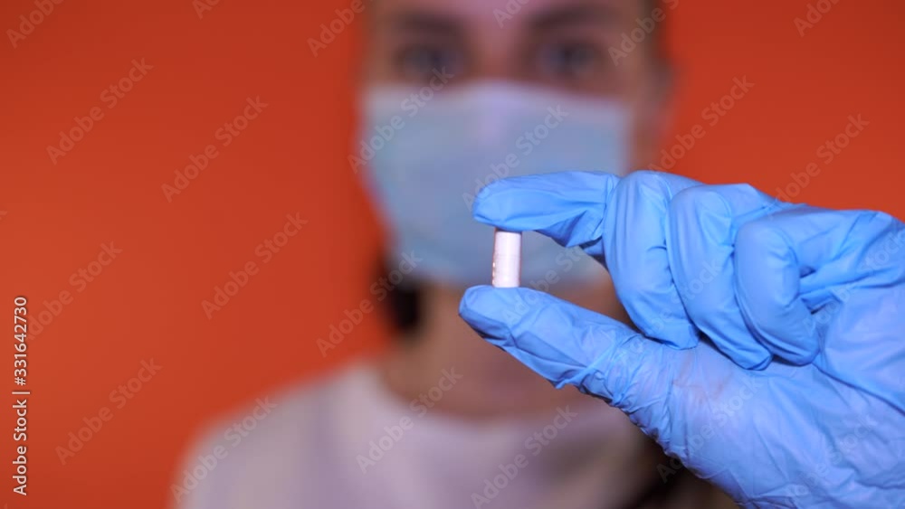 Close up of female doctor holding pill in hand. Pharmacist holding a pill. Female hand holding a white pill
