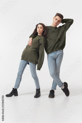 Equality. Trendy fashionable couple isolated on white studio background. Caucasian woman and man posing in basic minimal unisex clothes. Concept of relations, fashion, beauty, love. Inclusive.