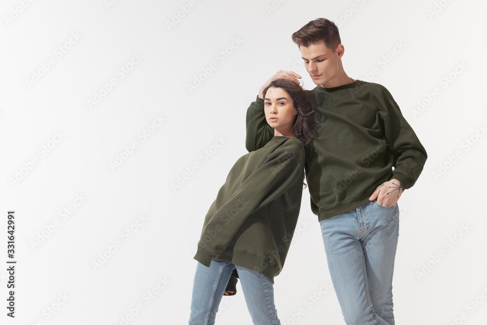 Equality. Trendy fashionable couple isolated on white studio background. Caucasian woman and man posing in basic minimal unisex clothes. Concept of relations, fashion, beauty, love. Inclusive. Equality. Trendy fashionable couple isolated on white studio background. Caucasian woman and man posing in basic minimal unisex clothes. Concept of relations, fashion, beauty, love. Inclusive.