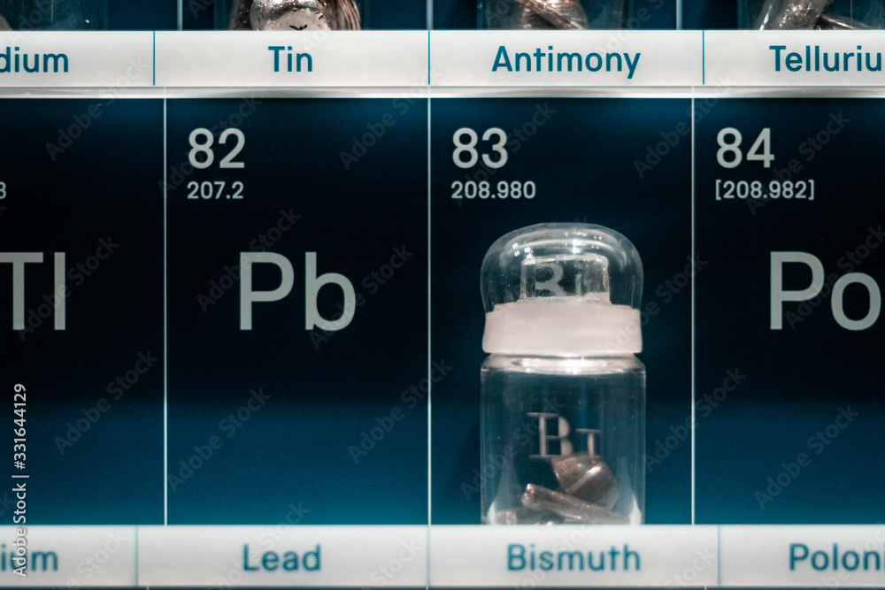 Biology concept. Chemistry lab, Tin and Antimony samples in glass vials, close up of periodic table of elements Biology concept. Chemistry lab, Tin and Antimony samples in glass vials, close up of periodic table of elements