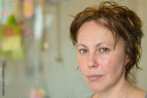 Thoughtful Hispanic woman with tousled curly hair