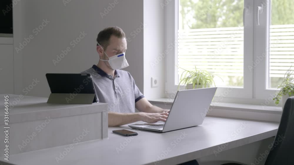 Verzweifelter Mann in quarantäne arbeitet am Laptop und schaut aus dem Fenster Verzweifelter Mann in quarantäne arbeitet am Laptop und schaut aus dem Fenster