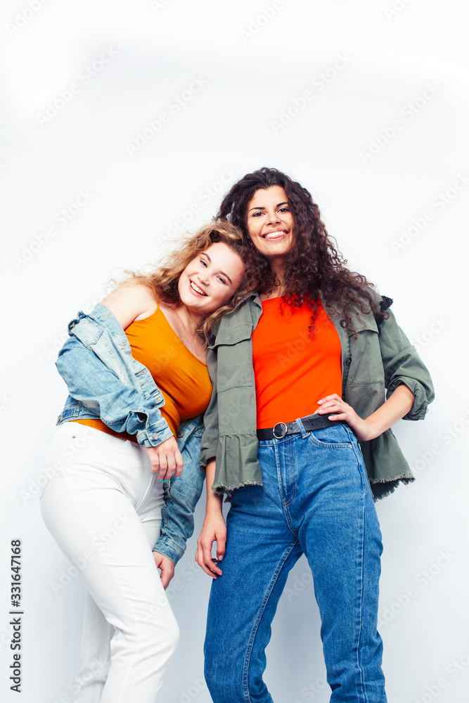 young pretty teenage girls friends with blond and brunette curly hairs posing cheerful isolated on white background, lifestyle people concept