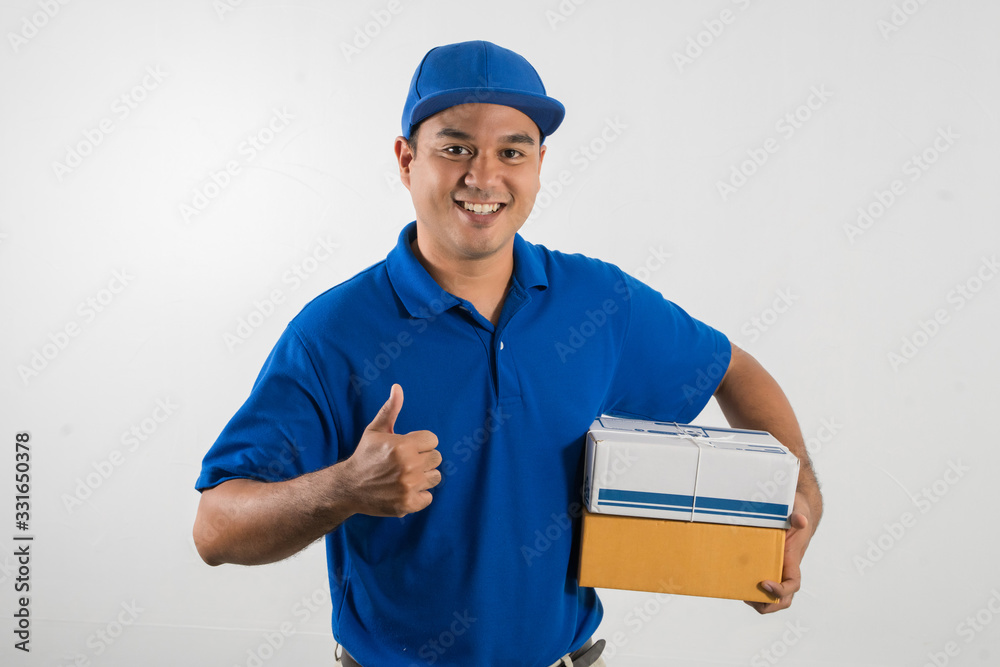 Blue Delivery handsome asian man holding parcel cardboard box on isolated white background. Blue Delivery handsome asian man holding parcel cardboard box on isolated white background.