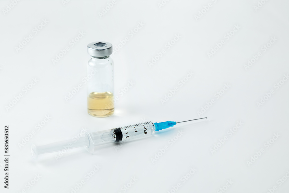A disposable injection syringe and a drug ampoule on a white background. The place for an inscription A disposable injection syringe and a drug ampoule on a white background. The place for an inscription