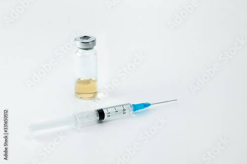 A disposable injection syringe and a drug ampoule on a white background. The place for an inscription