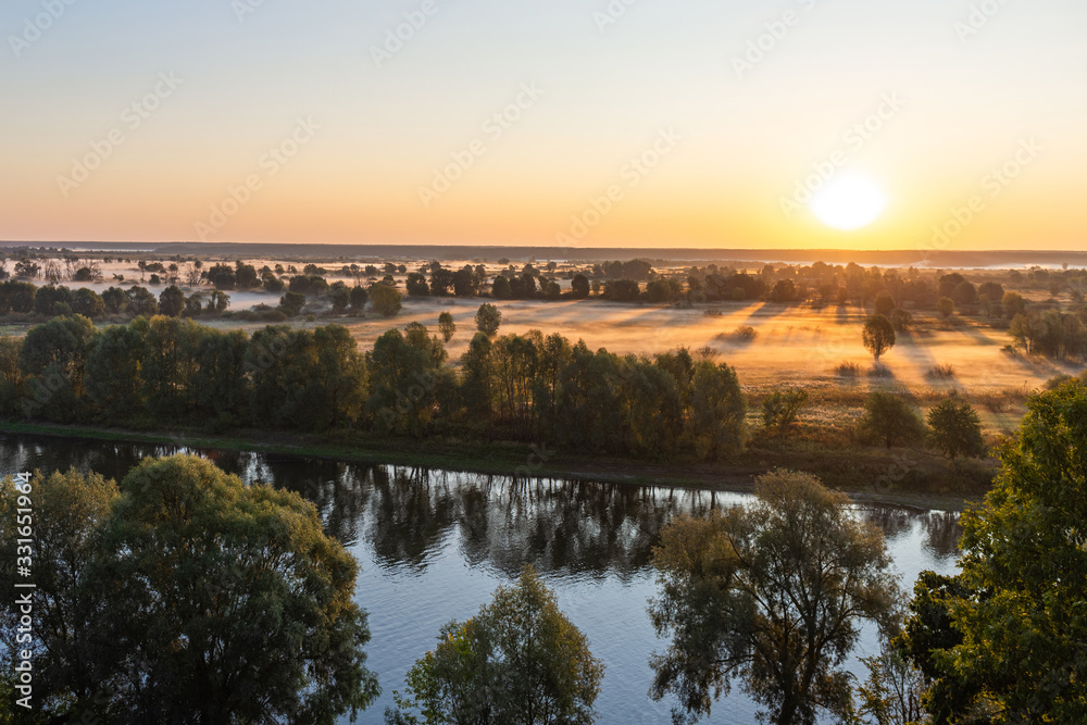 Amazing perfect morning foggy landscape in scenic countryside of Ukraine. Aerial view at horizon line, meadows, green forests and dark long shadows of sunrise sun seen on misty ground.