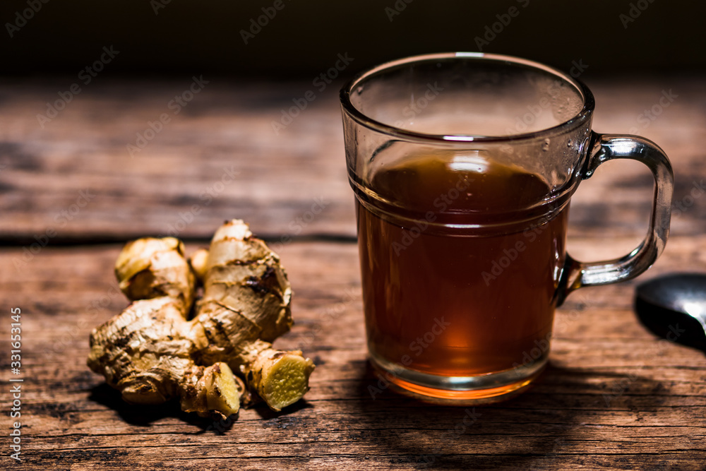 Tea in a transparent glass with ginger. Concept of herbal medicine from Asia which contains antioxidants is believed to be good for health. Zingiber officinale. Tea in a transparent glass with ginger. Concept of herbal medicine from Asia which contains antioxidants is believed to be good for health. Zingiber officinale.