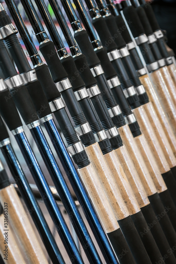 different rods and spinning rods for fishing on the counter in the store. Shallow depth of field different rods and spinning rods for fishing on the counter in the store. Shallow depth of field