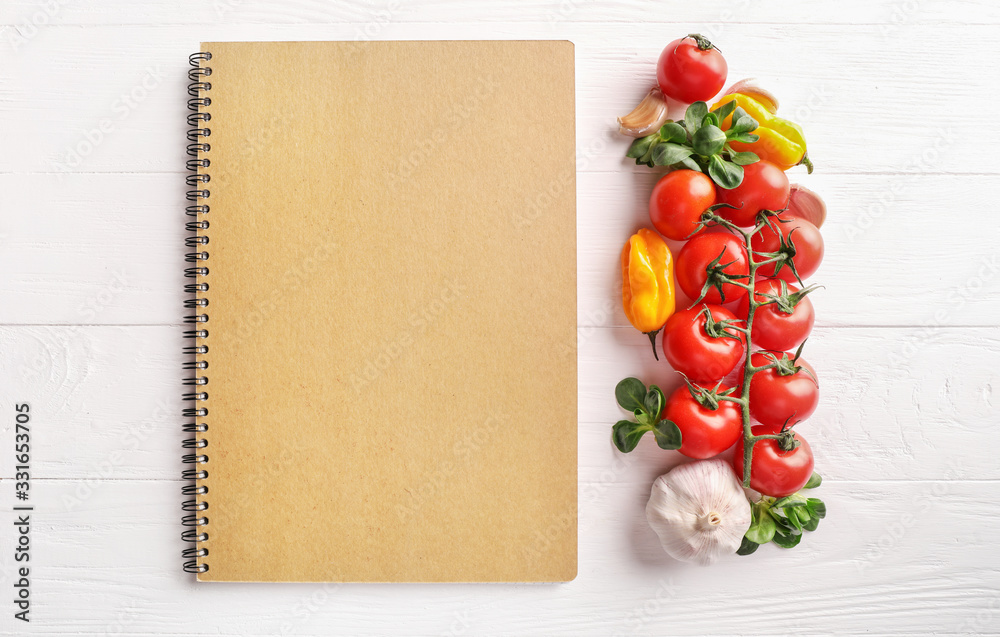 Recipe book and vegetables on white wooden background Recipe book and vegetables on white wooden background