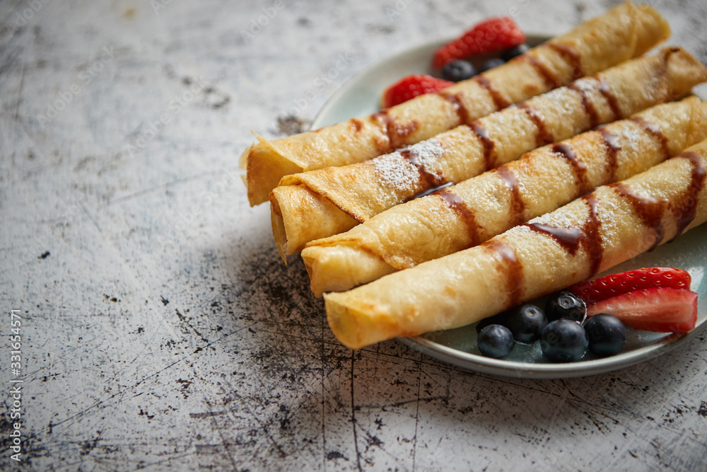 Plate of delicious crepes roll with fresh fruits and chocolate Plate of delicious crepes roll with fresh fruits and chocolate