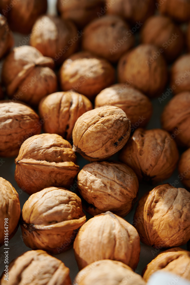 Whole walnuts, vertical close-up shot in harsh sunlight. Whole walnuts, vertical close-up shot in harsh sunlight.