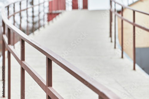 road going up is fenced with metal handrails with a railing.