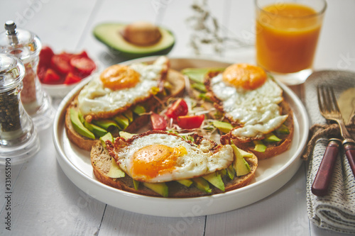 Delicious healthy breakfast with sliced avocado sandwiches with fried egg