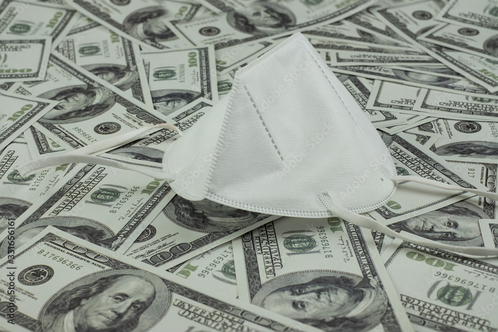 Doctor mask and virus protection and money a stack of 100 US dollars banknote a lot of, That was It costs expensive price and high priced products concept Doctor mask and virus protection and money a stack of 100 US dollars banknote a lot of, That was It costs expensive price and high priced products concept