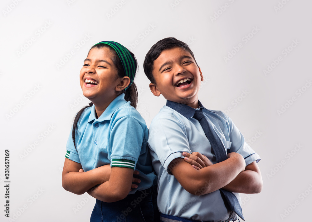 Cheerful Indian school kids in uniform standing isolated over white
