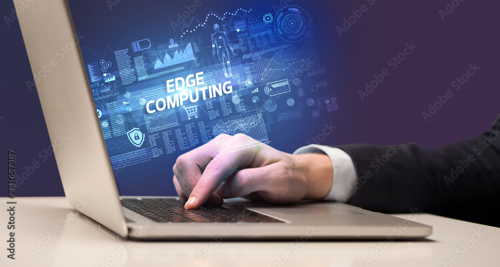 Businessman working on laptop with EDGE COMPUTING inscription, cyber technology concept Businessman working on laptop with EDGE COMPUTING inscription, cyber technology concept