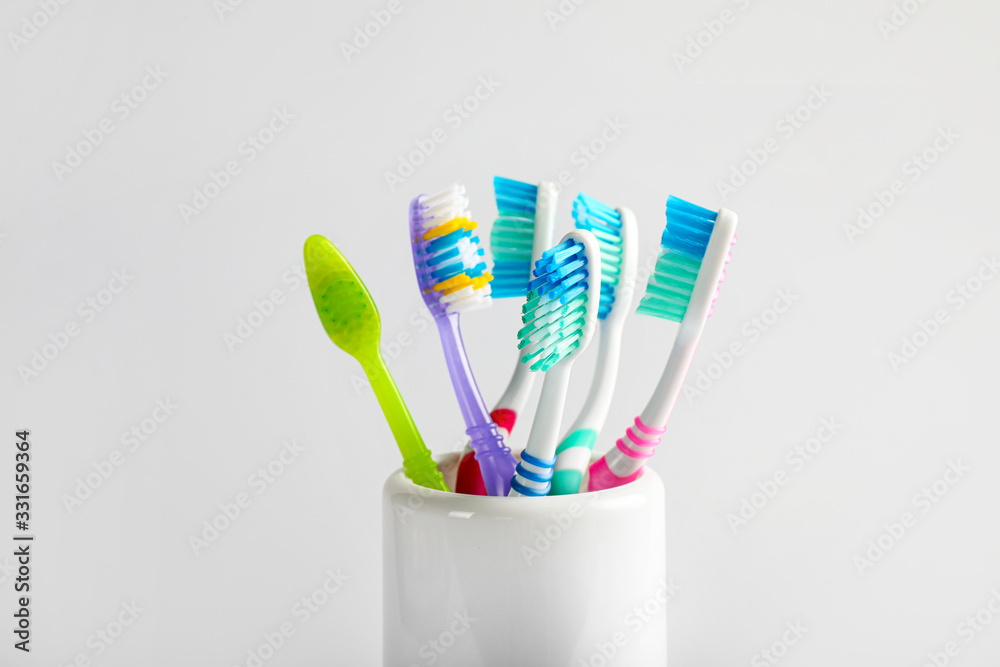 Plastic toothbrushes in cup on white background Plastic toothbrushes in cup on white background