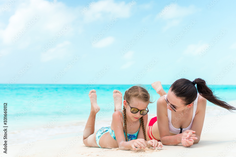 Beautiful mother and daughter on the beach