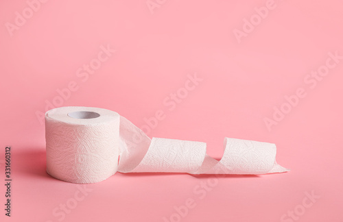 Toilet paper roll on pink background photo