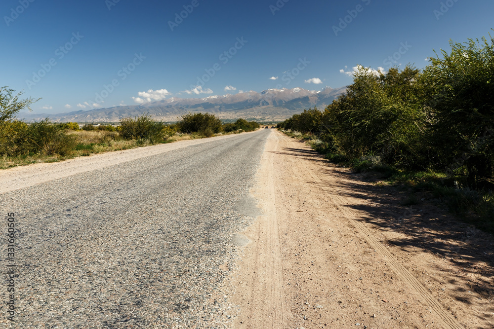 asphalt road along the southern shore of Lake Issyk-Kul in Kyrgyzstan.