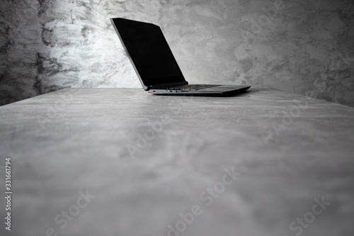 Otwarty laptop na stole, betonowe tło