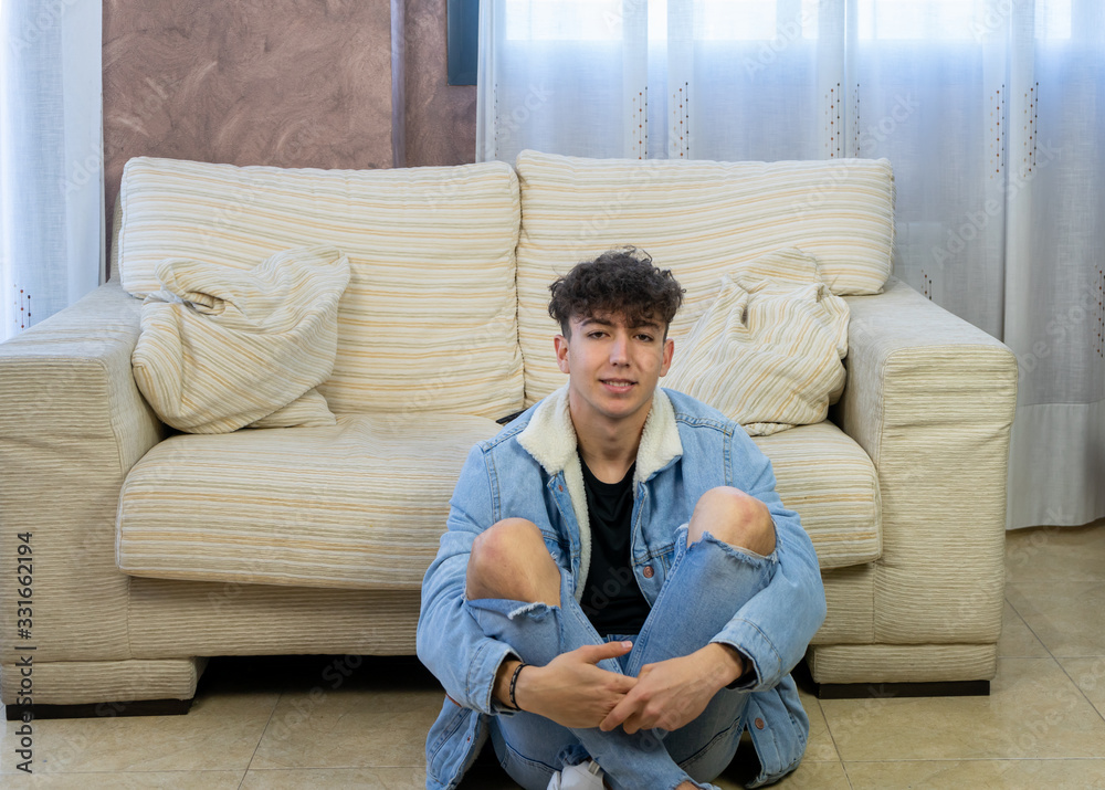 Young man posing on a living room sofa Young man posing on a living room sofa