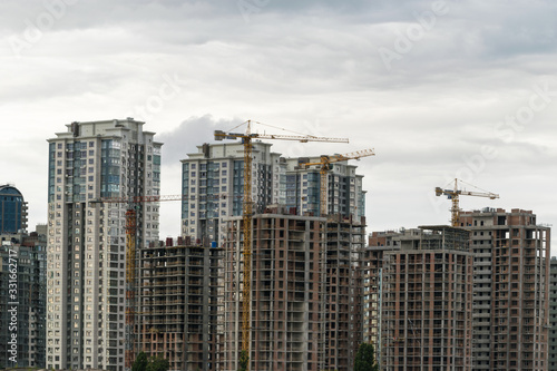 Buildings under construction. Lifting cranes © azure