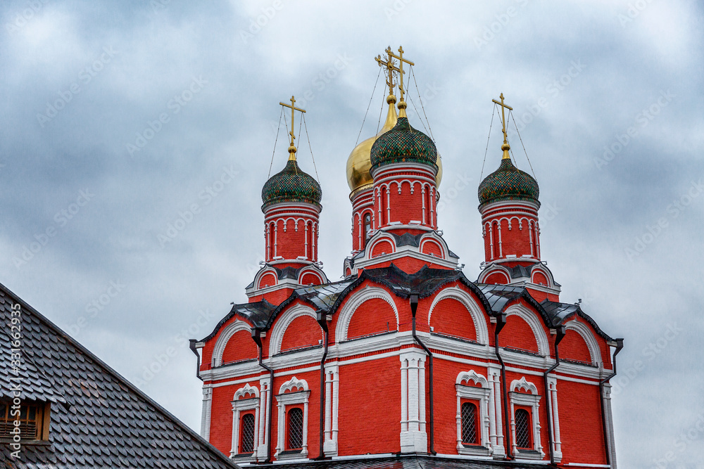 Beautiful red Christian church in the center of Moscow on a gllomy sky background. Close-up.