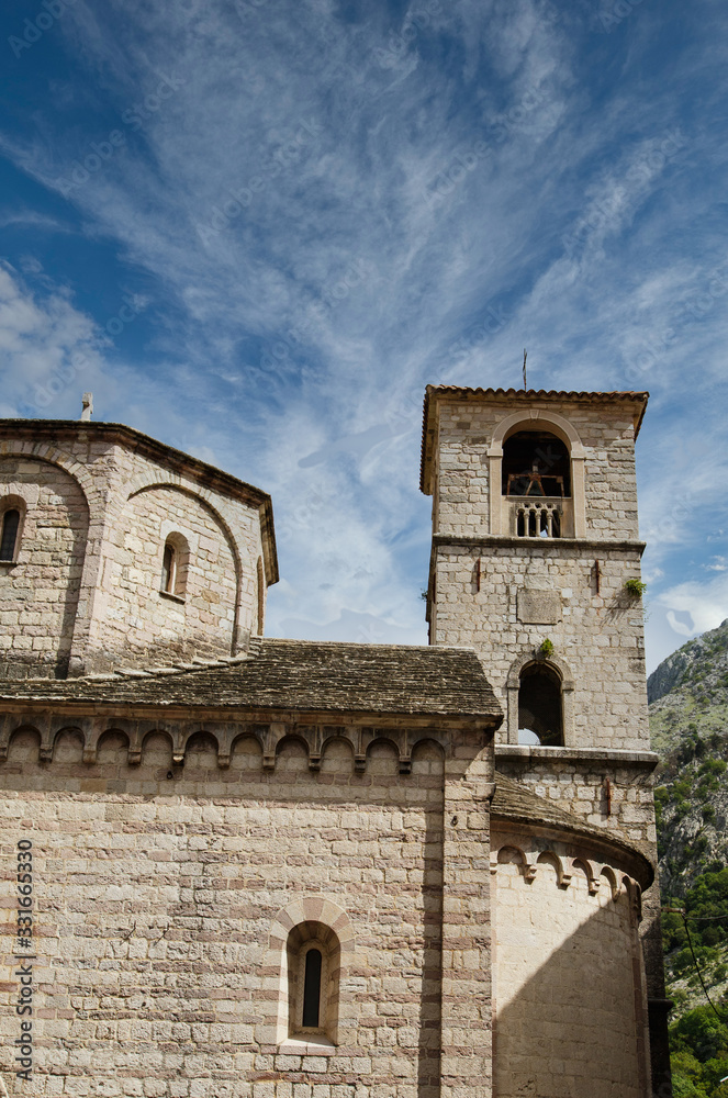 Old stone church and bell tower under blue sky in Kotor, Montenegro Old stone church and bell tower under blue sky in Kotor, Montenegro
