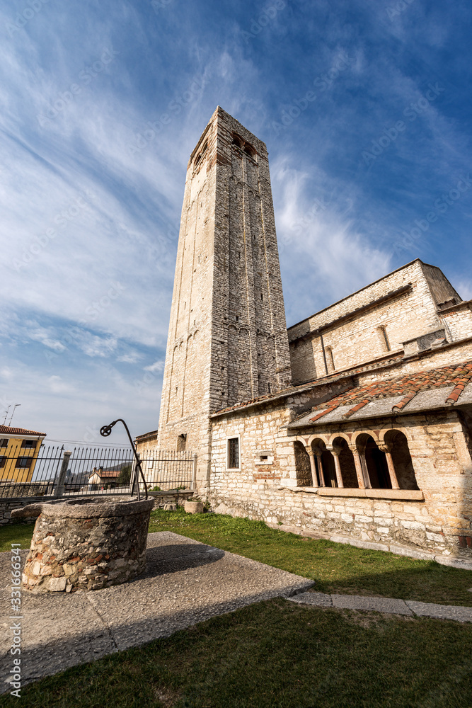 Ancient Romanic parish Church of San Giorgio di Valpolicella or Ingannapoltron (VII - XI century), with the bell tower, the cloister and the well. Veneto, Verona province, Italy, Europe