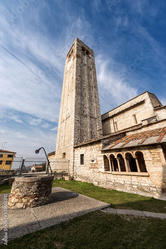Ancient Romanic parish Church of San Giorgio di Valpolicella or Ingannapoltron (VII - XI century), with the bell tower, the cloister and the well. Veneto, Verona province, Italy, Europe