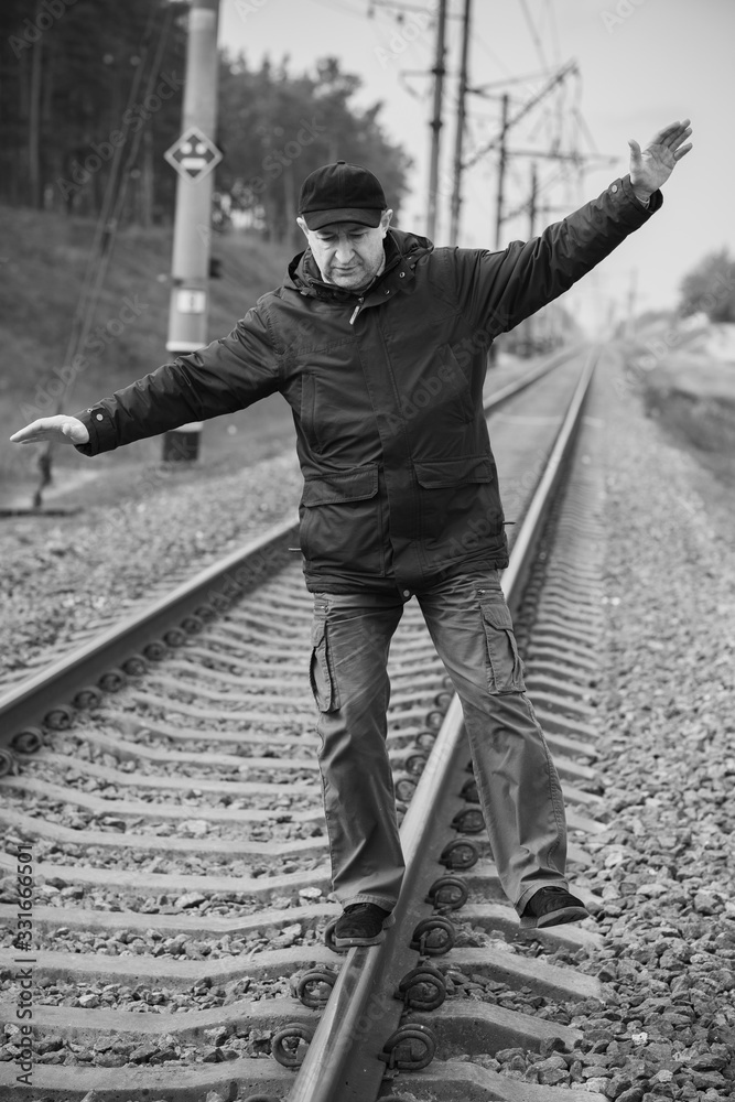 Mature senior man on Railway, don't joke with rails 